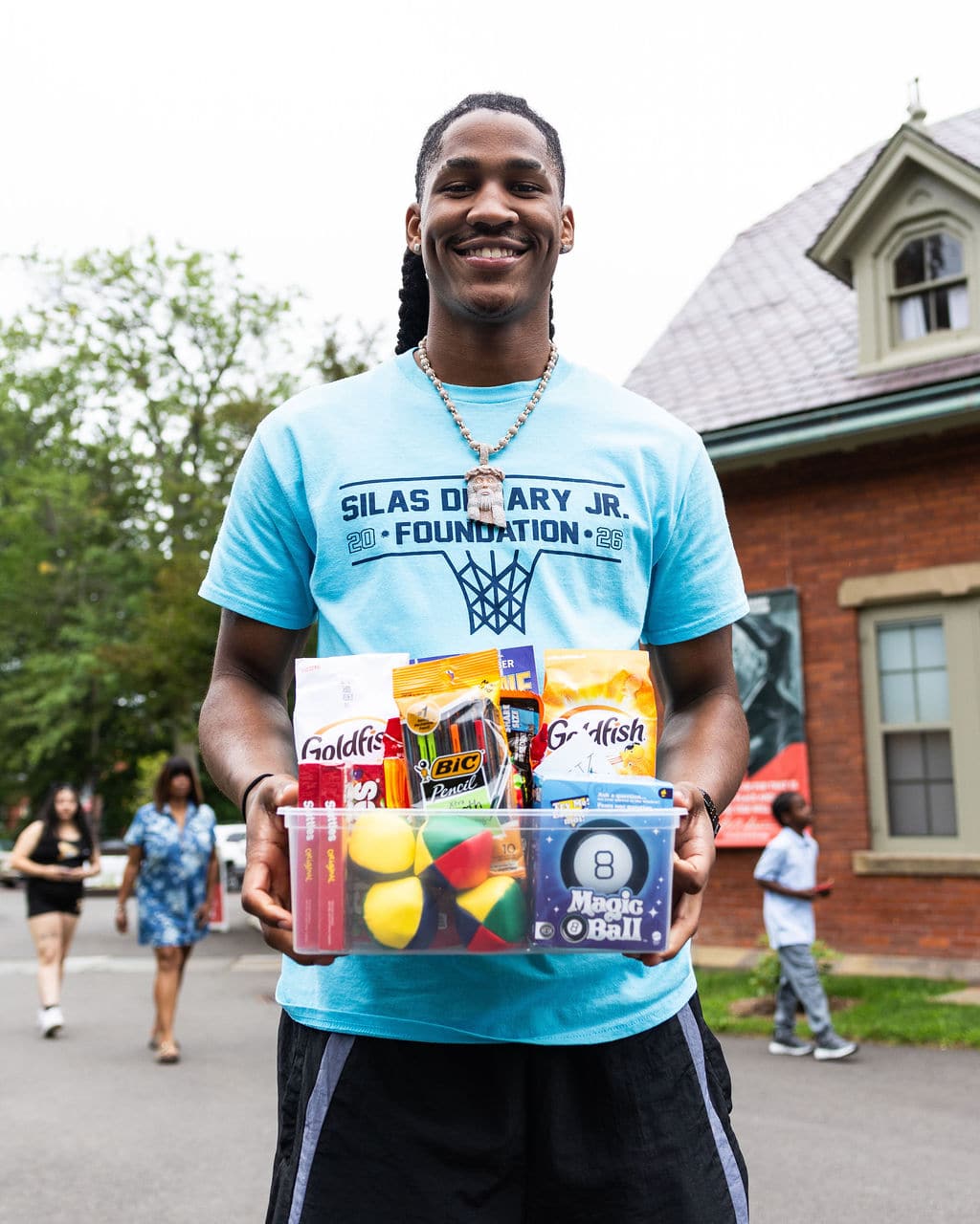 Silas Demary Jr. holding a box of school supplies and toys
