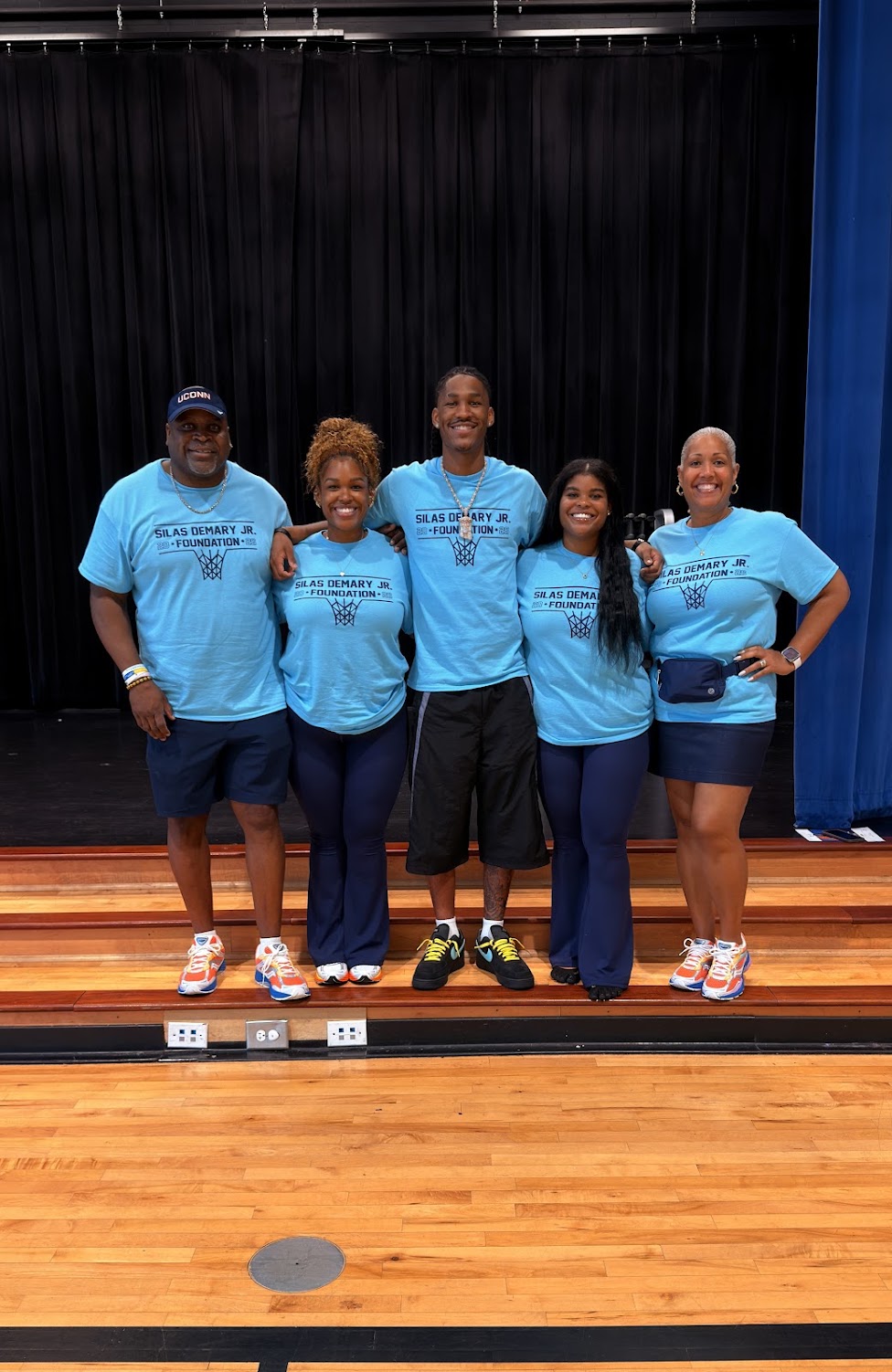 The Demary family poses together on stage in matching foundation shirts at the 2026 Raleigh Back to School Bash.