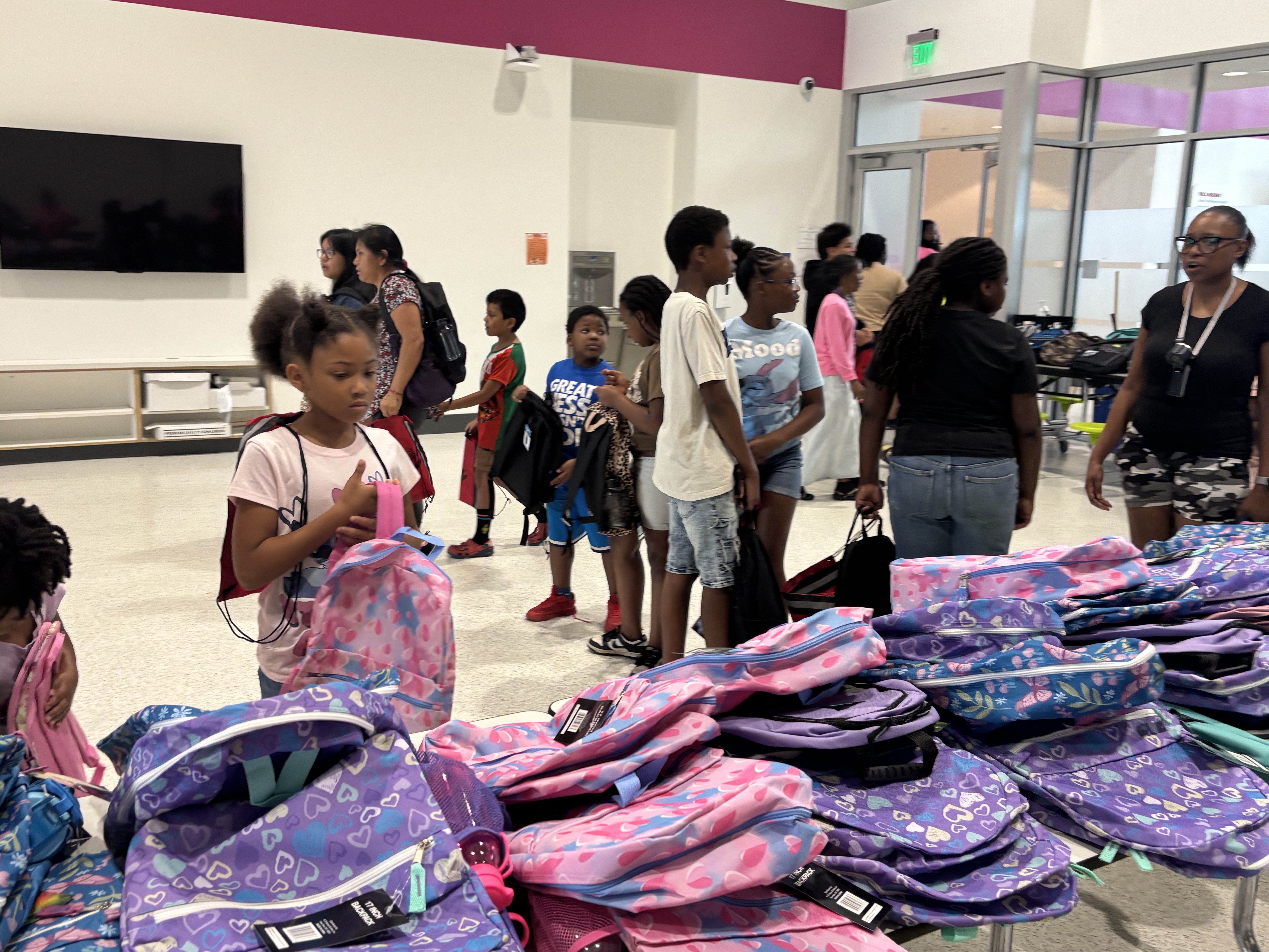 A student picks out a backpack from the tables of new bags at the 2025 Back to School Bash.