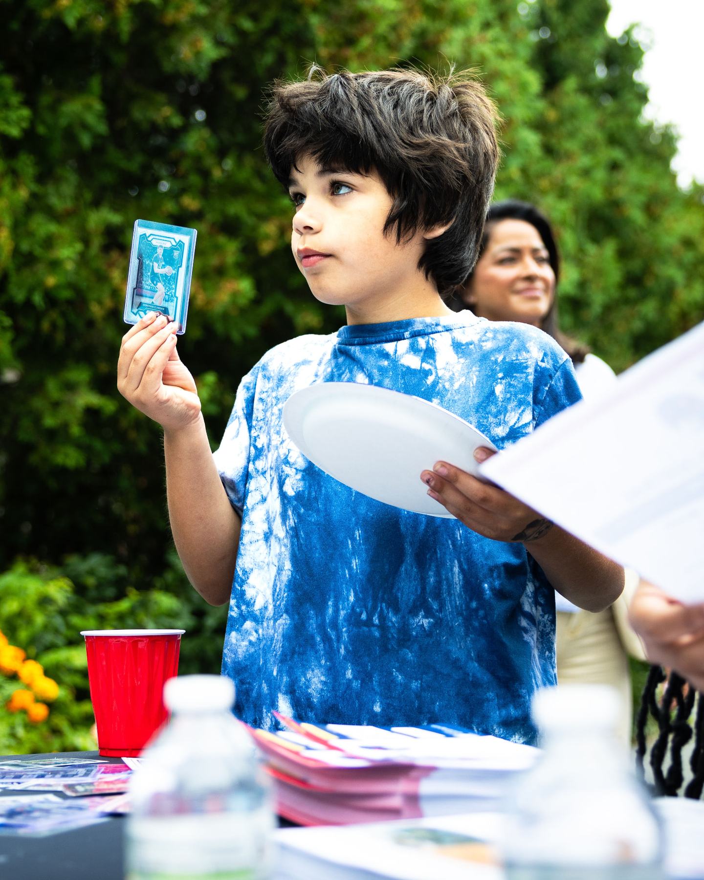 A young guest holding up a basketball trading card