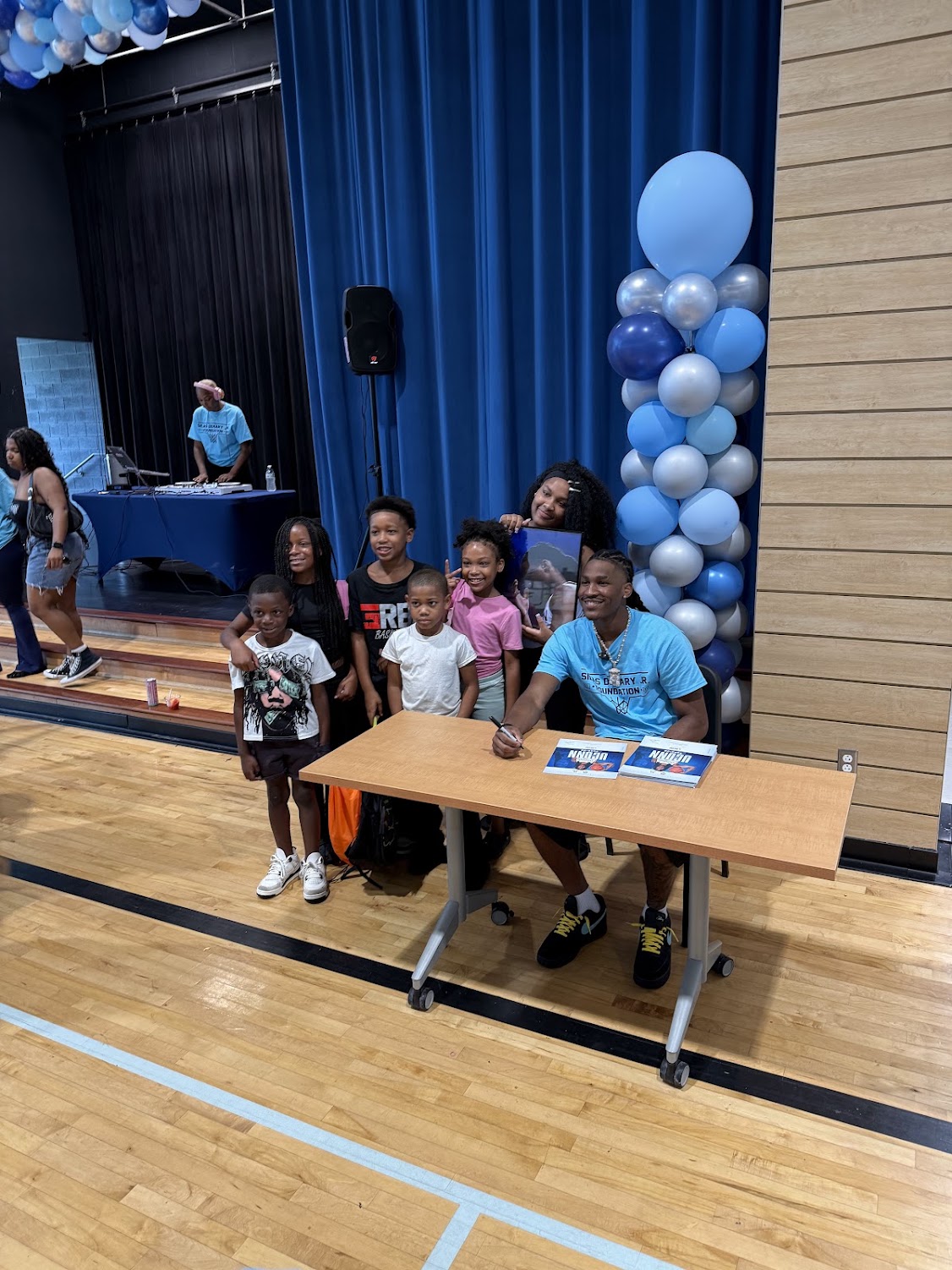 Silas Demary Jr. signs autographs for a group of children at the Raleigh bash.