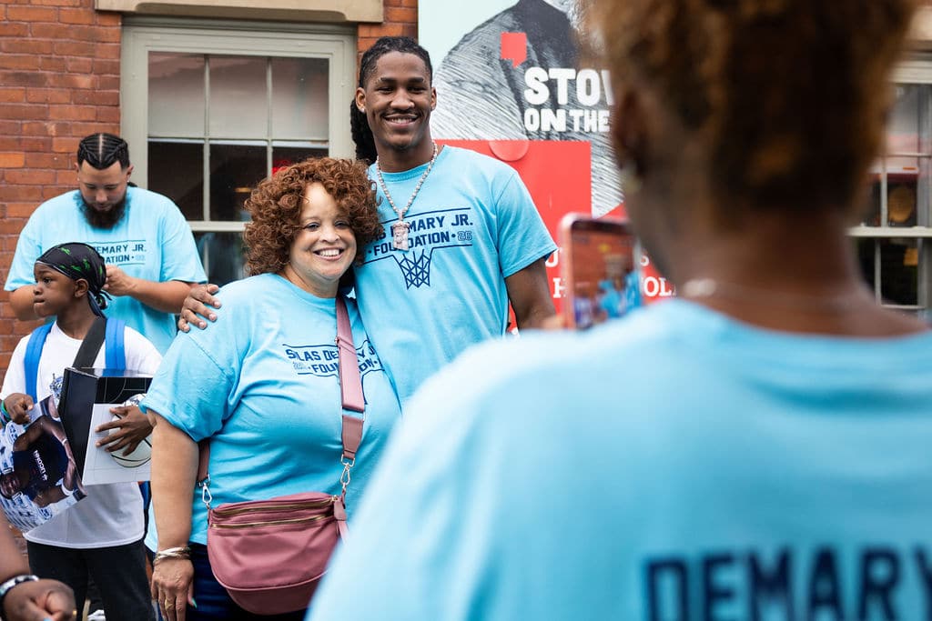 Families posing for photos with Silas Demary Jr. outside the event