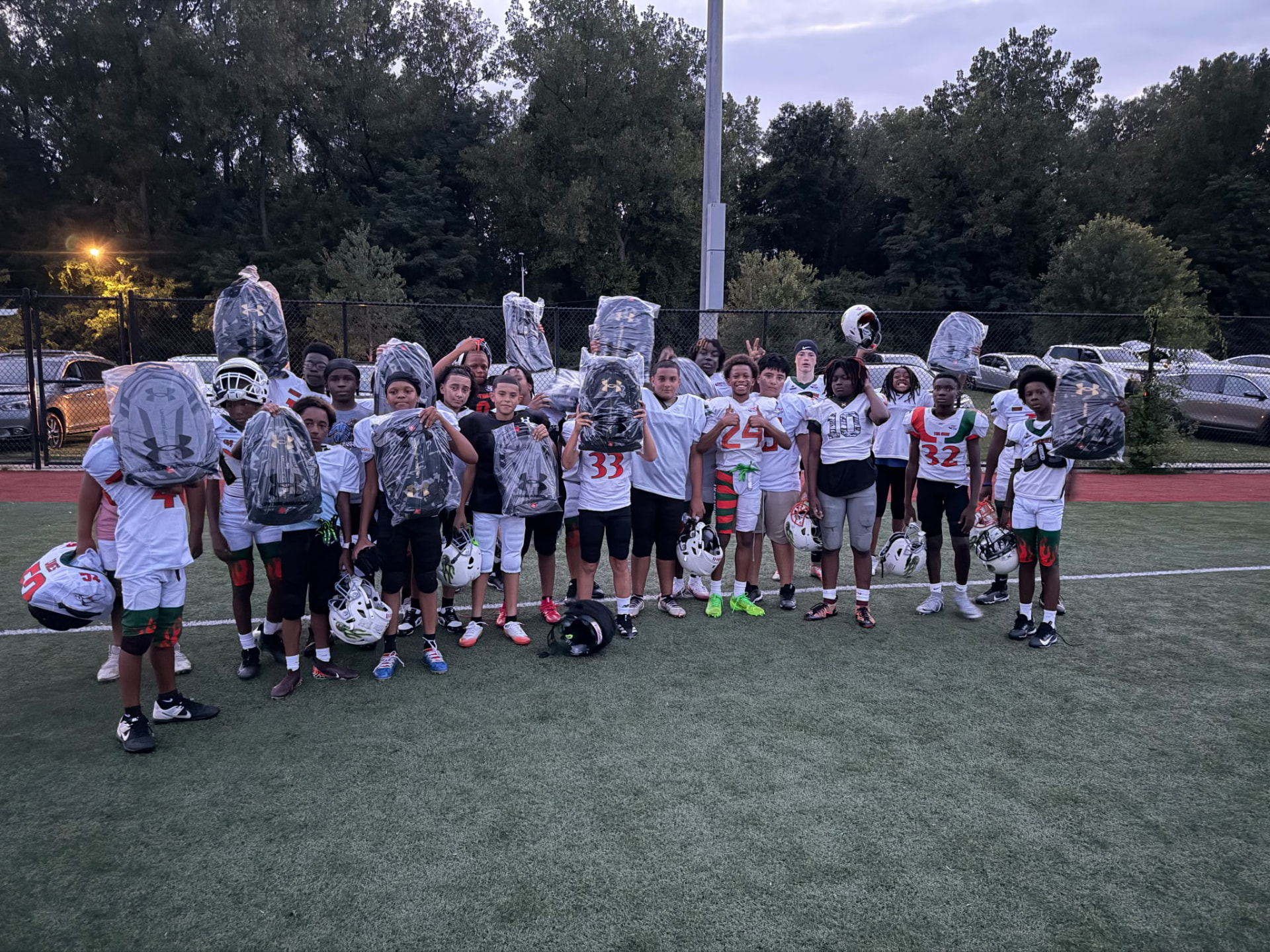 Young Hartford Hurricanes 12U players hold up their new foundation-supplied gear after practice.