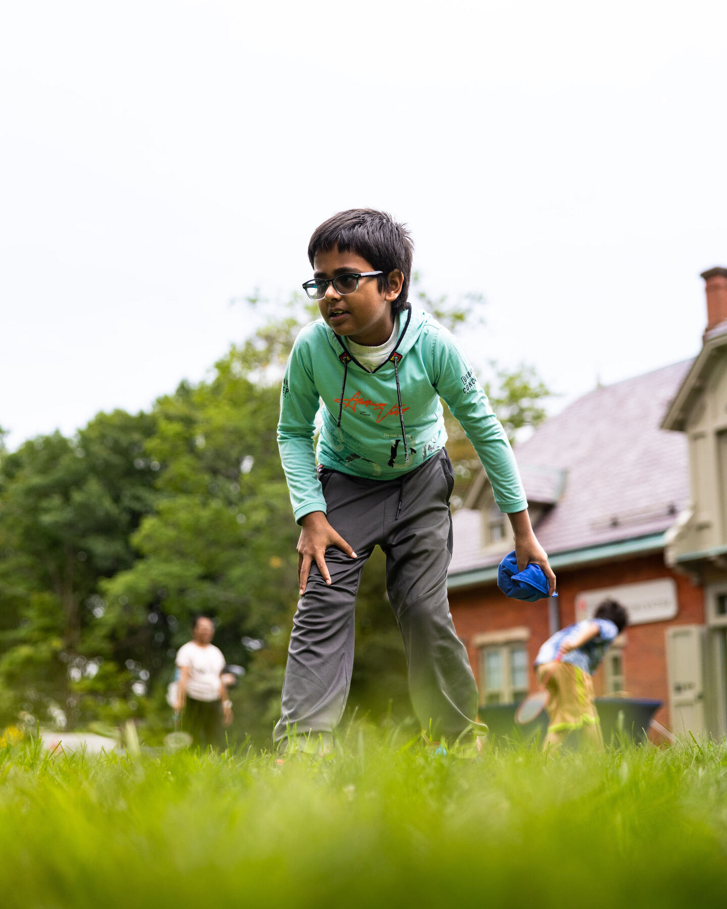 A child playing a bean bag toss game on the green