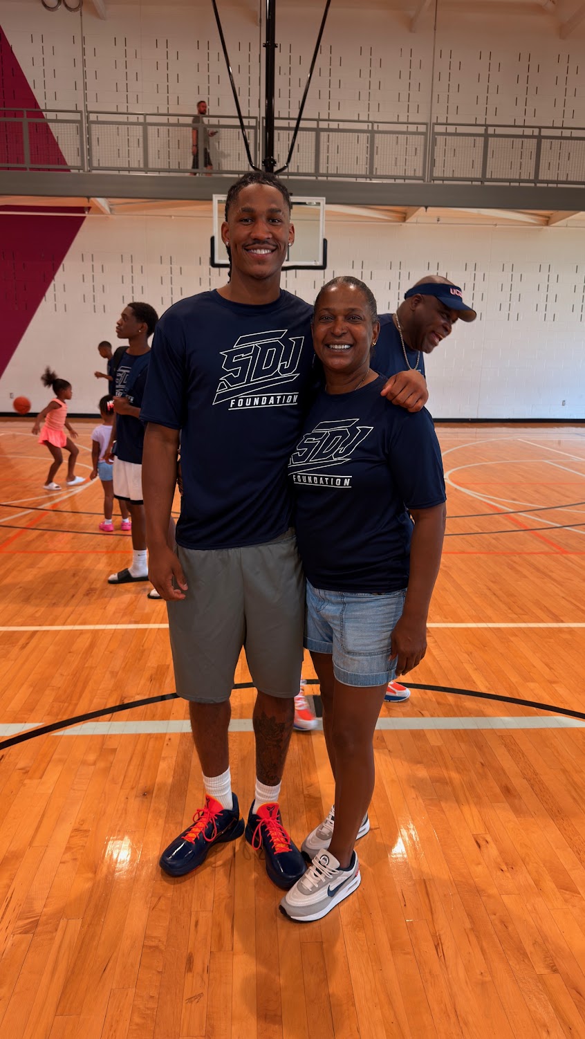 Silas Demary Jr. poses for a photo with a supporter wearing matching foundation shirts at the Raleigh bash.