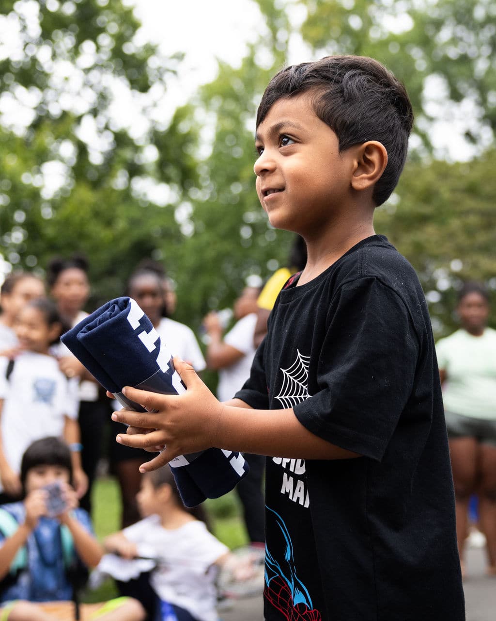 A young boy holding a t-shirt at the Hartford bash