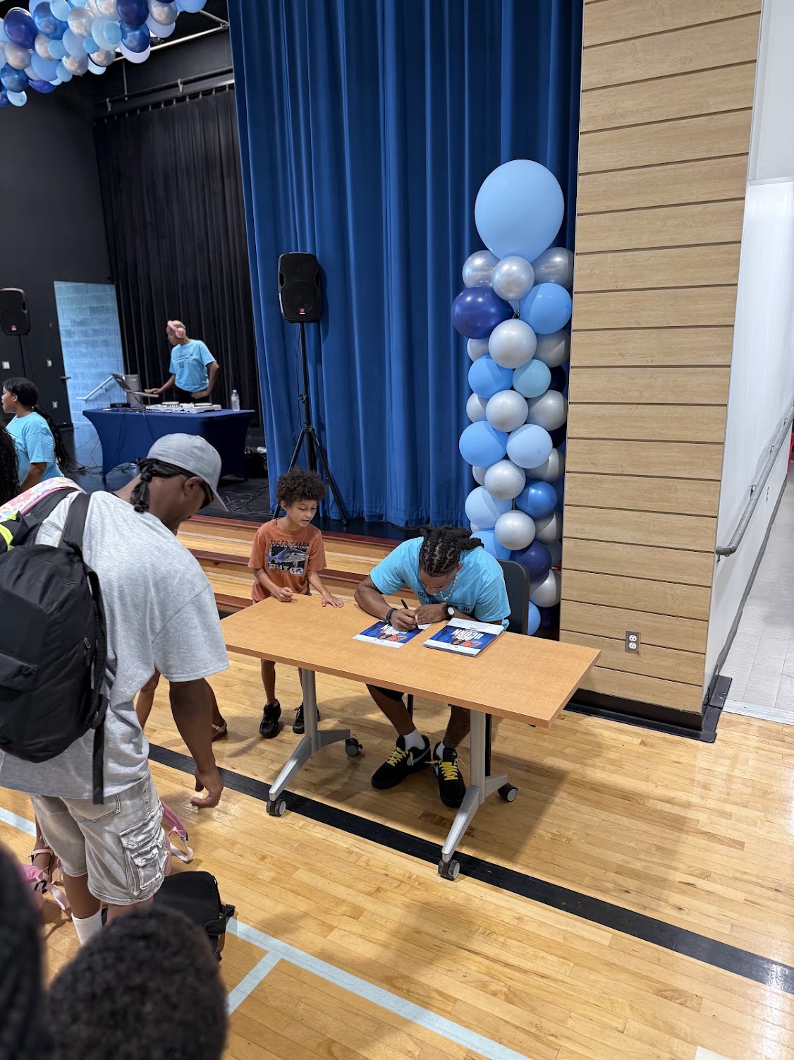 Silas Demary Jr. signs an autograph for a young boy at the 2026 Raleigh Back to School Bash.