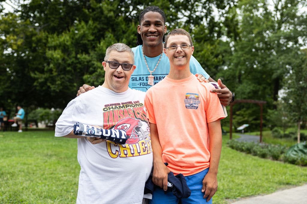 Silas Demary Jr. with two young guests on the lawn