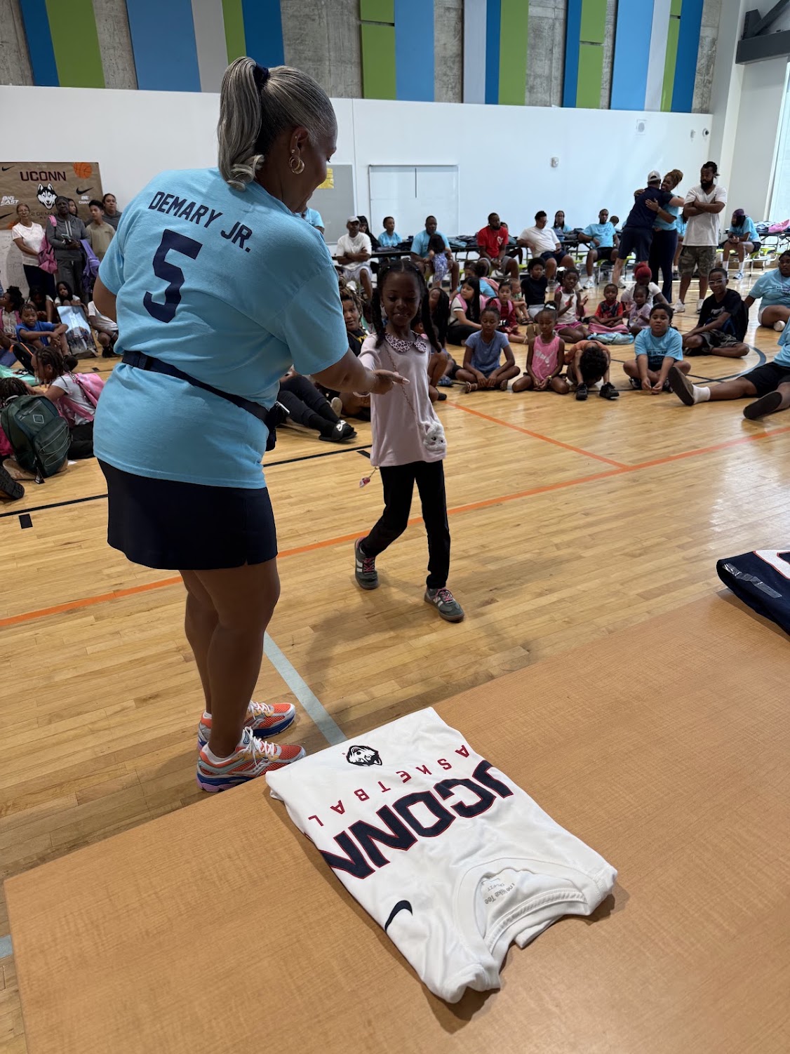 Shanté Demary welcomes a young girl to join an activity in front of the crowd at the Raleigh bash.