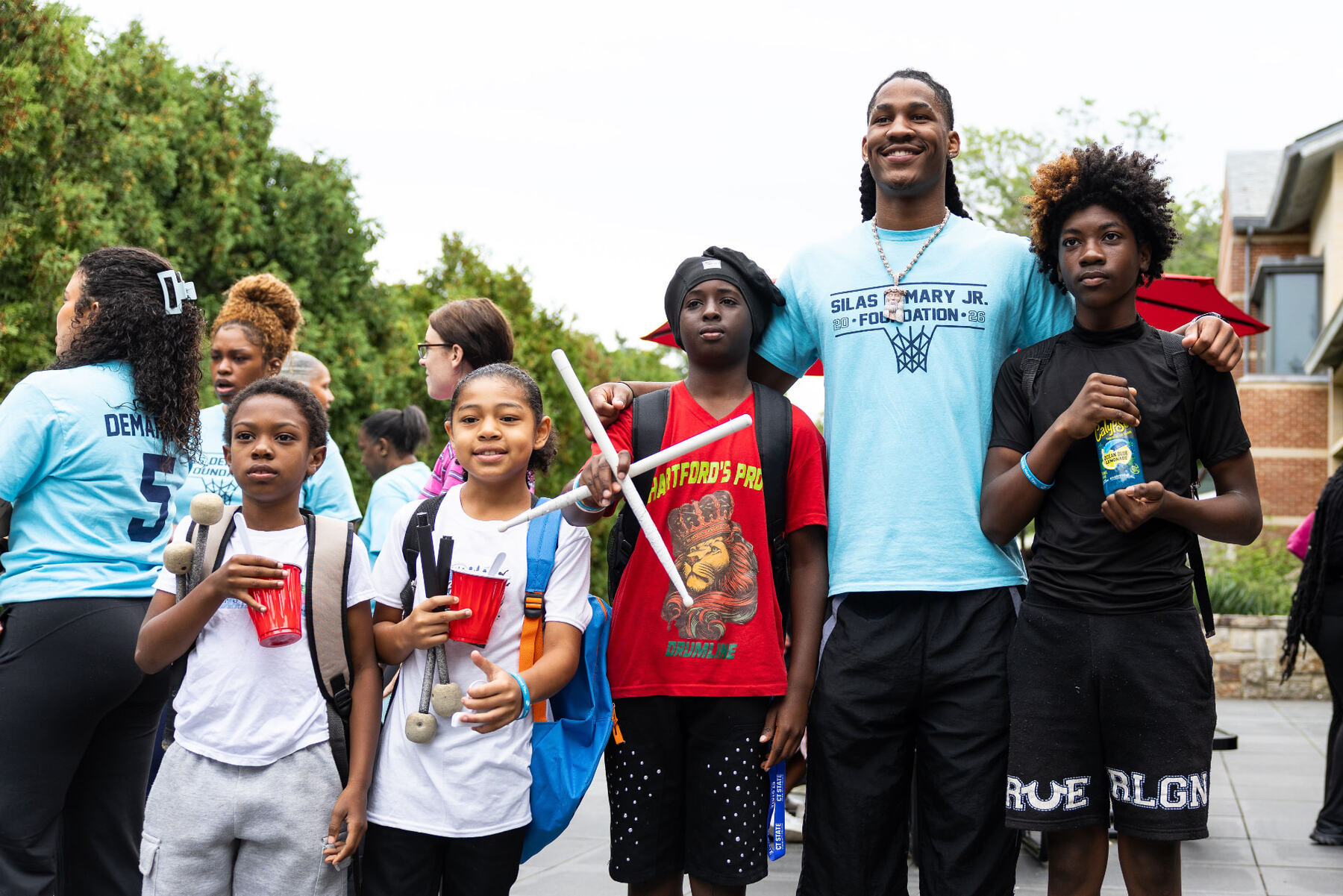 Silas Demary Jr. with kids and drumline members at the bash