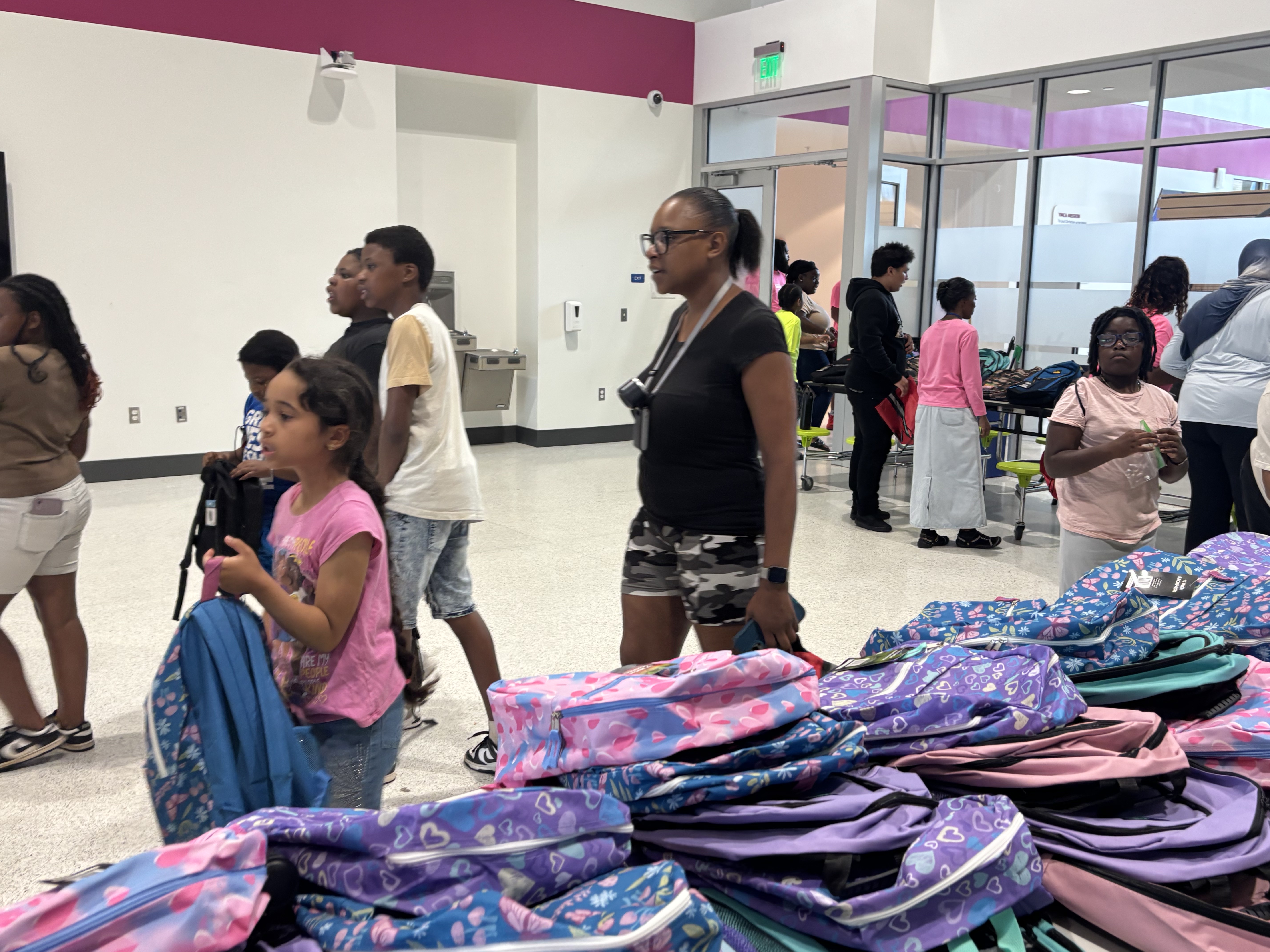 Families move through the backpack giveaway line at the 2025 Back to School Bash.