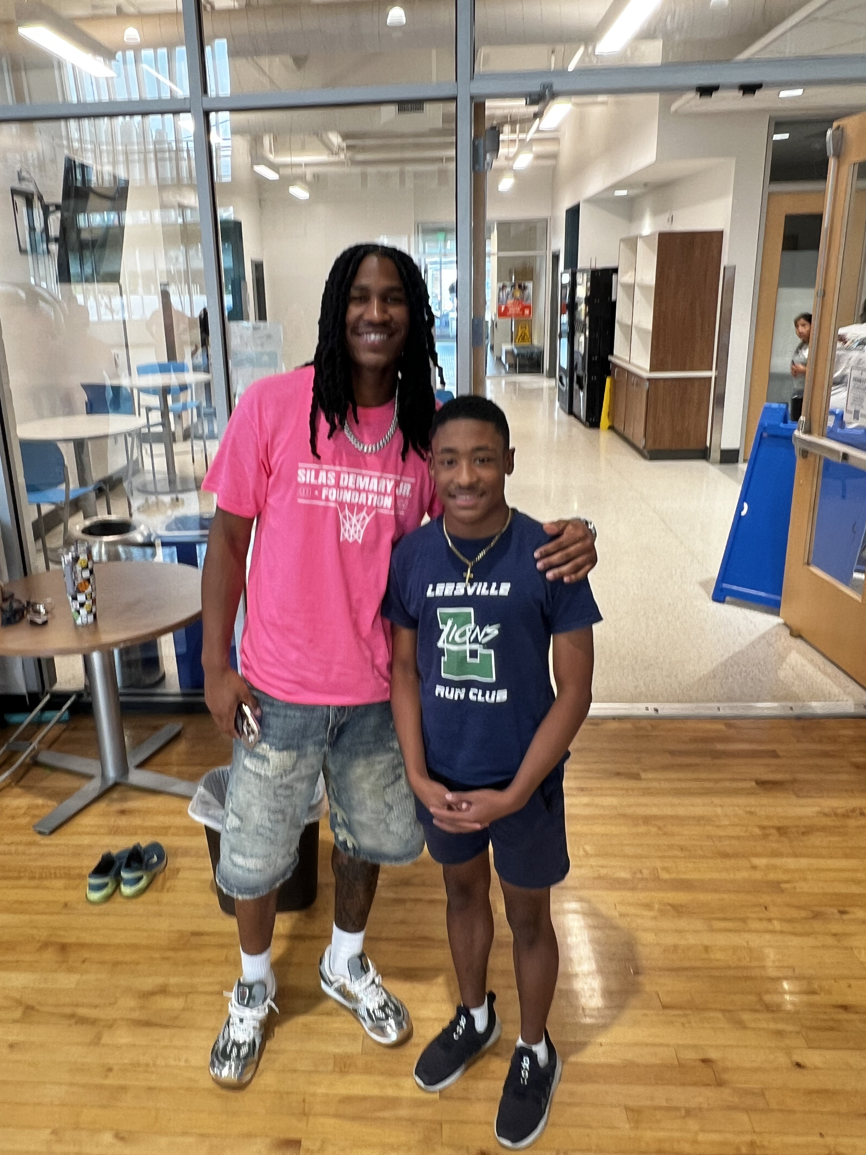 Silas Demary Jr. poses with a student in a Leesville Lions Run Club shirt at the 2025 Back to School Bash.