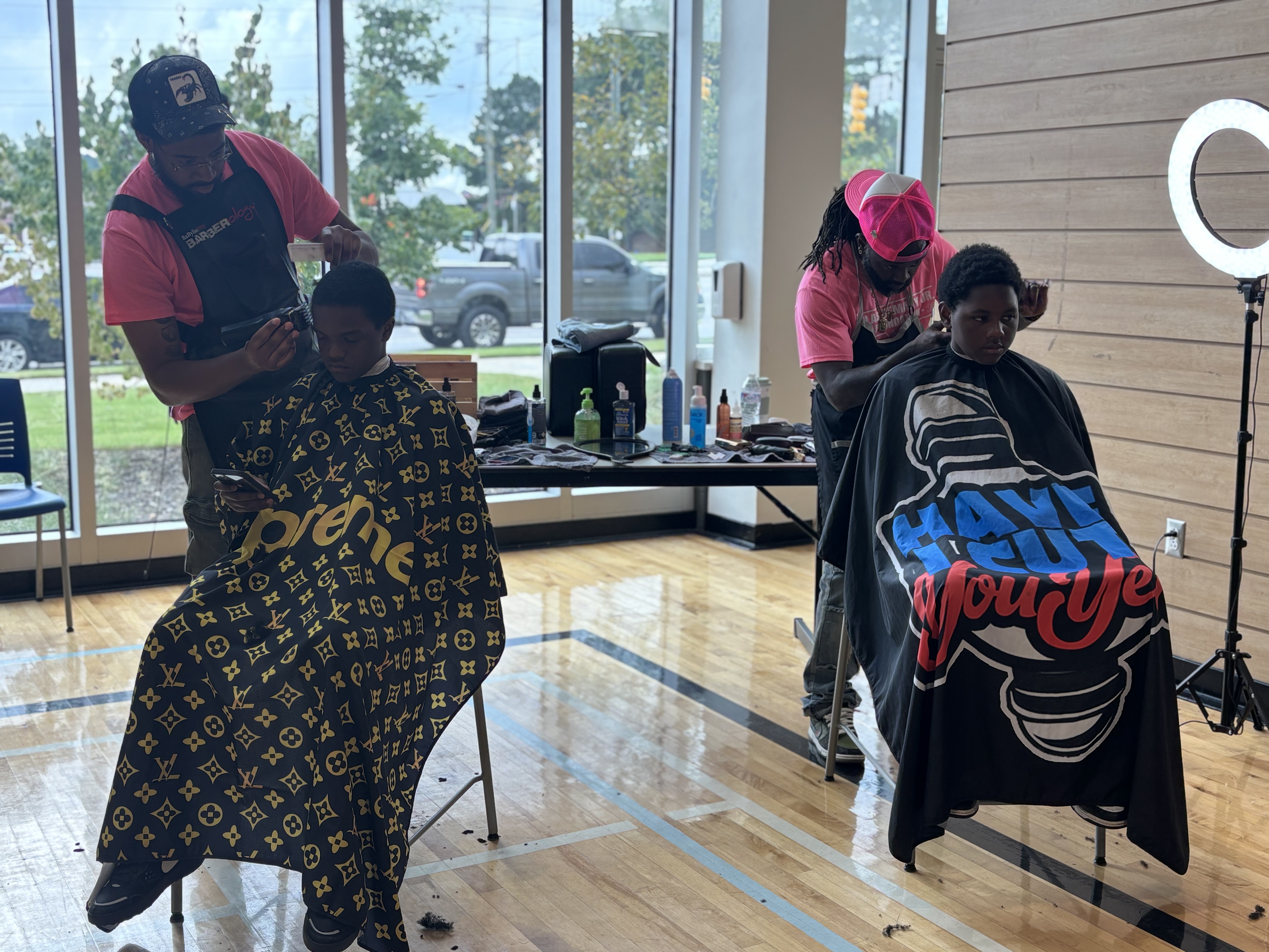 Students get fresh cuts side by side at the free barber station at the 2025 Back to School Bash.