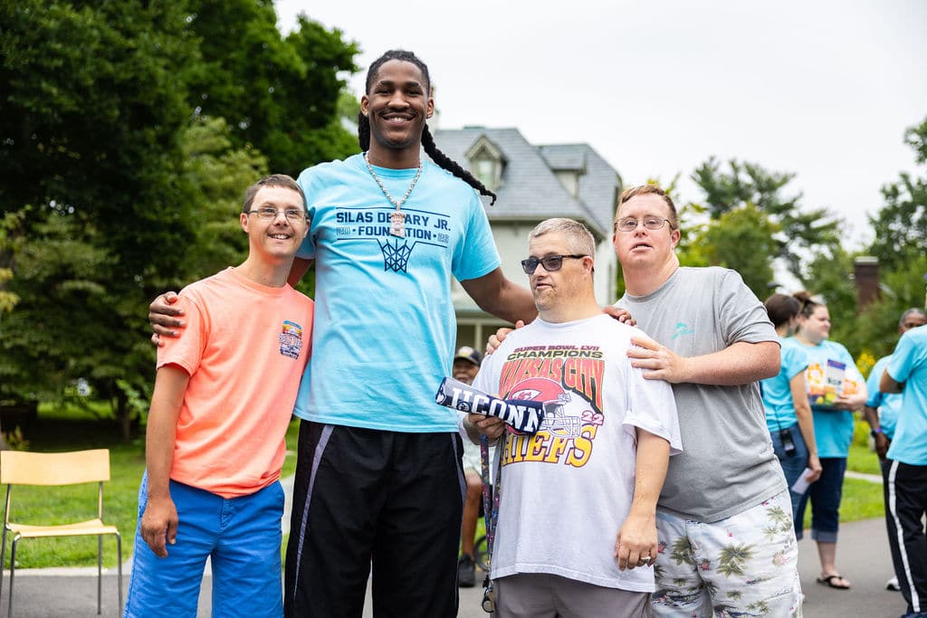 Silas Demary Jr. posing with three guests at the bash
