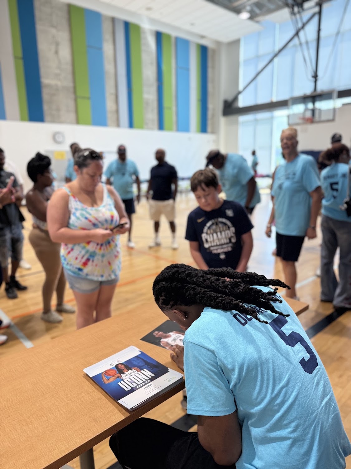Close-up of Silas Demary Jr. signing an autograph for fans at the Raleigh bash.