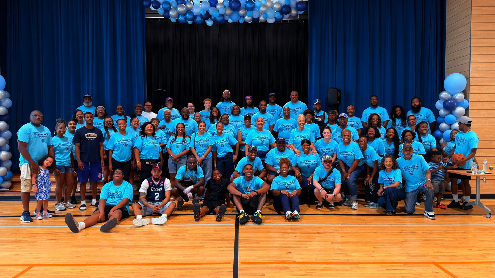 Volunteers and supporters gather for a group photo on stage at the 2026 Raleigh Back to School Bash.