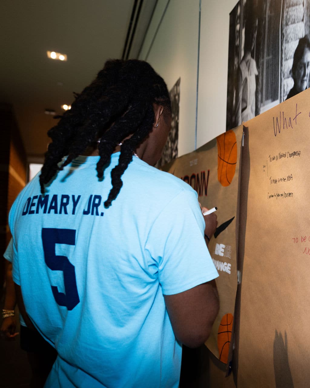 Silas Demary Jr. writing on the goals wall at the event