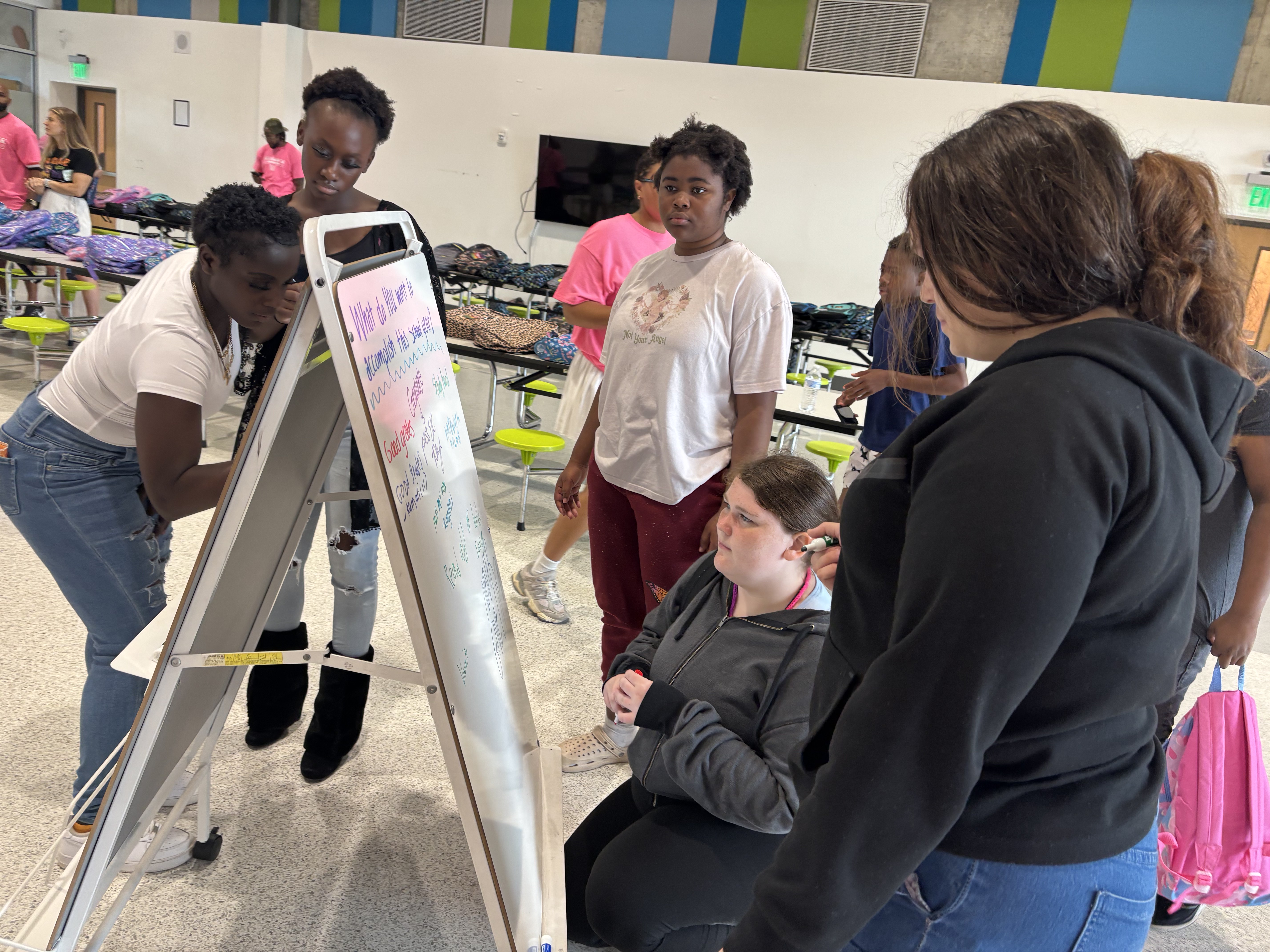 Students write their goals for the school year on a whiteboard at the 2025 Back to School Bash.