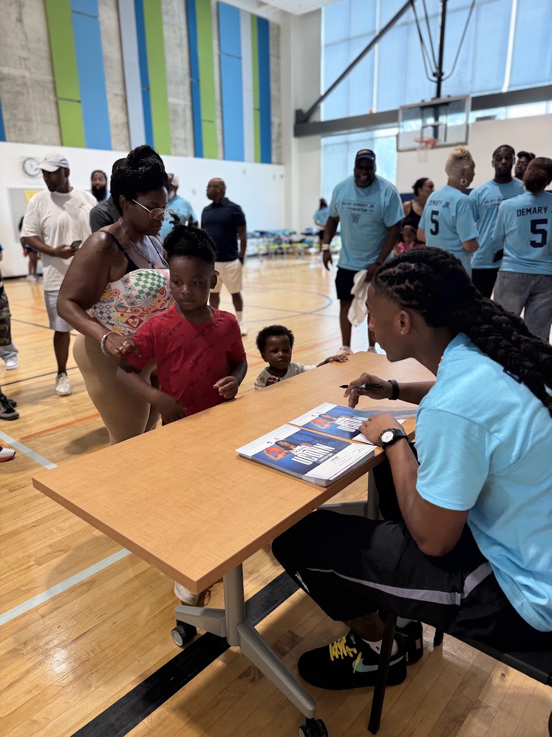 Silas Demary Jr. signs an autograph for a family at the 2026 Raleigh Back to School Bash.